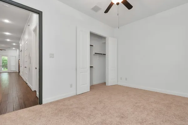 an empty room with chandelier fan
