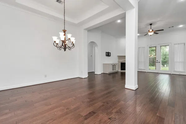 an empty room with wooden floor and a large mirror
