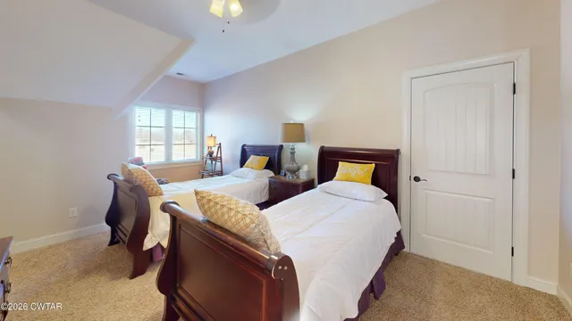 a bedroom with two beds and a window