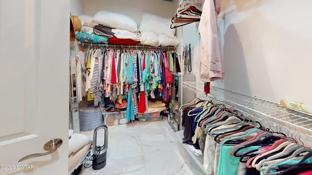 a view of walk in closet with clothes