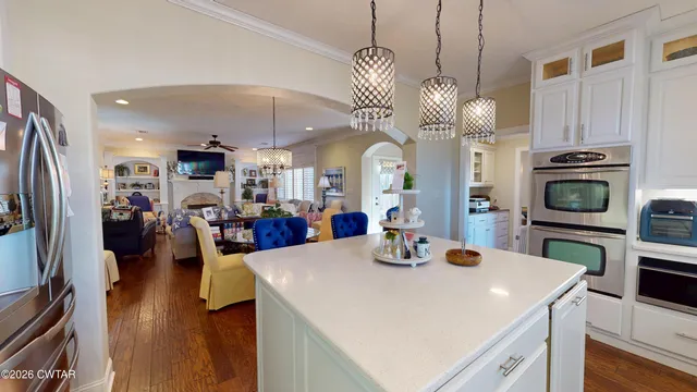 a view of a dining room and livingroom with furniture wooden floor a chandelier
