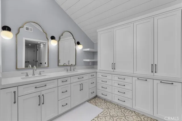 a bathroom with double sink and a mirror