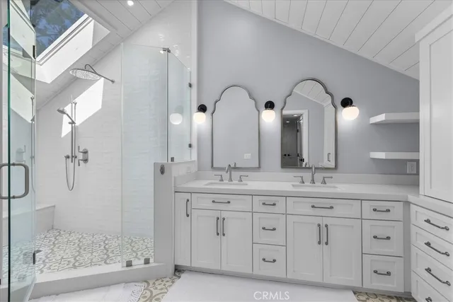 a bathroom with a double vanity sink mirror and shower
