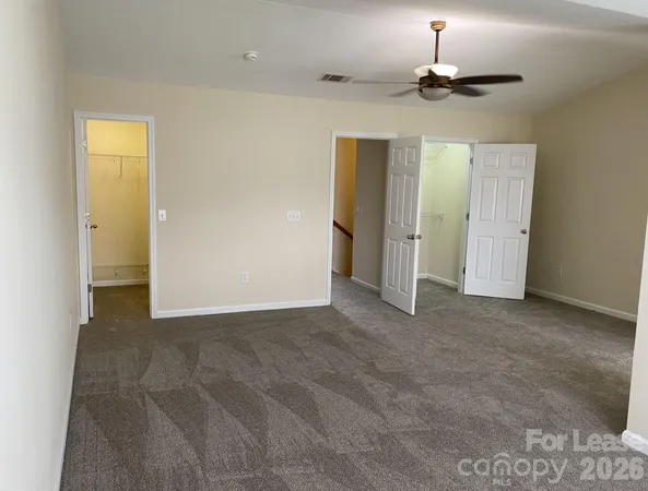 an empty room with windows and closet