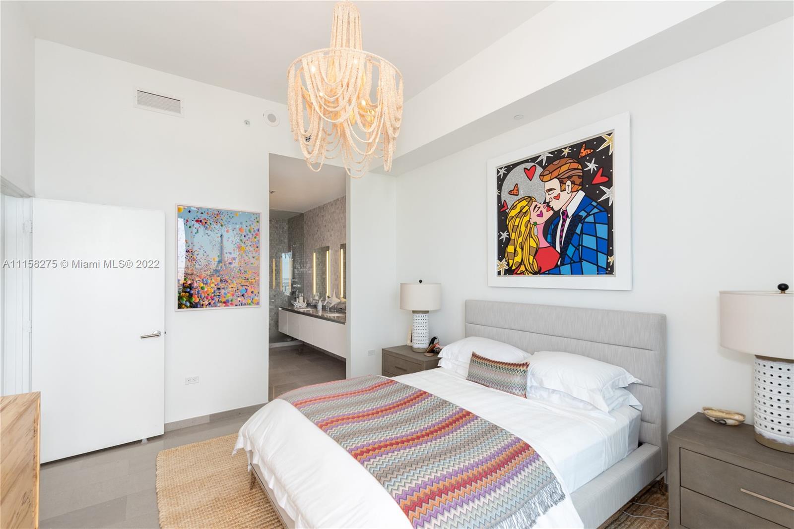 88 Southwest 7th Street, Unit 4110 Miami, FL 33130 - Photo 11 of 33 a bedroom with a bed and a chandelier