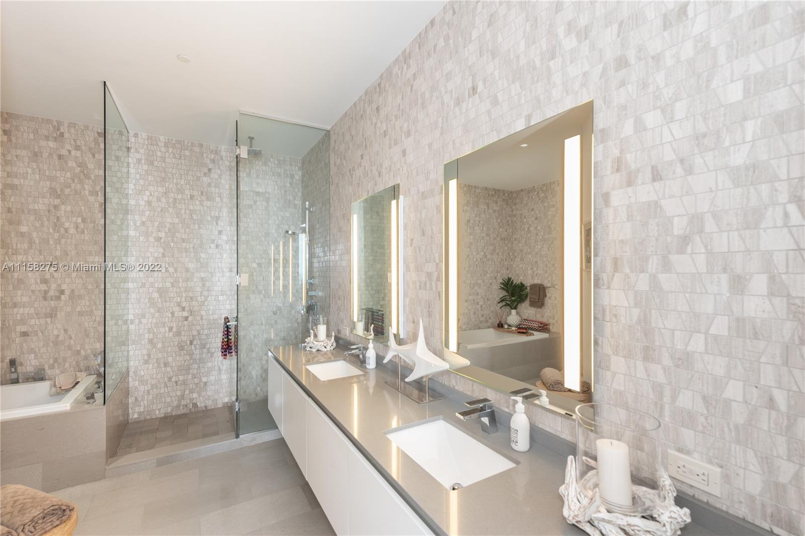 88 Southwest 7th Street, Unit 4110 Miami, FL 33130 - Photo 12 of 33 a spacious bathroom with a double vanity sink a mirror and a bathtub