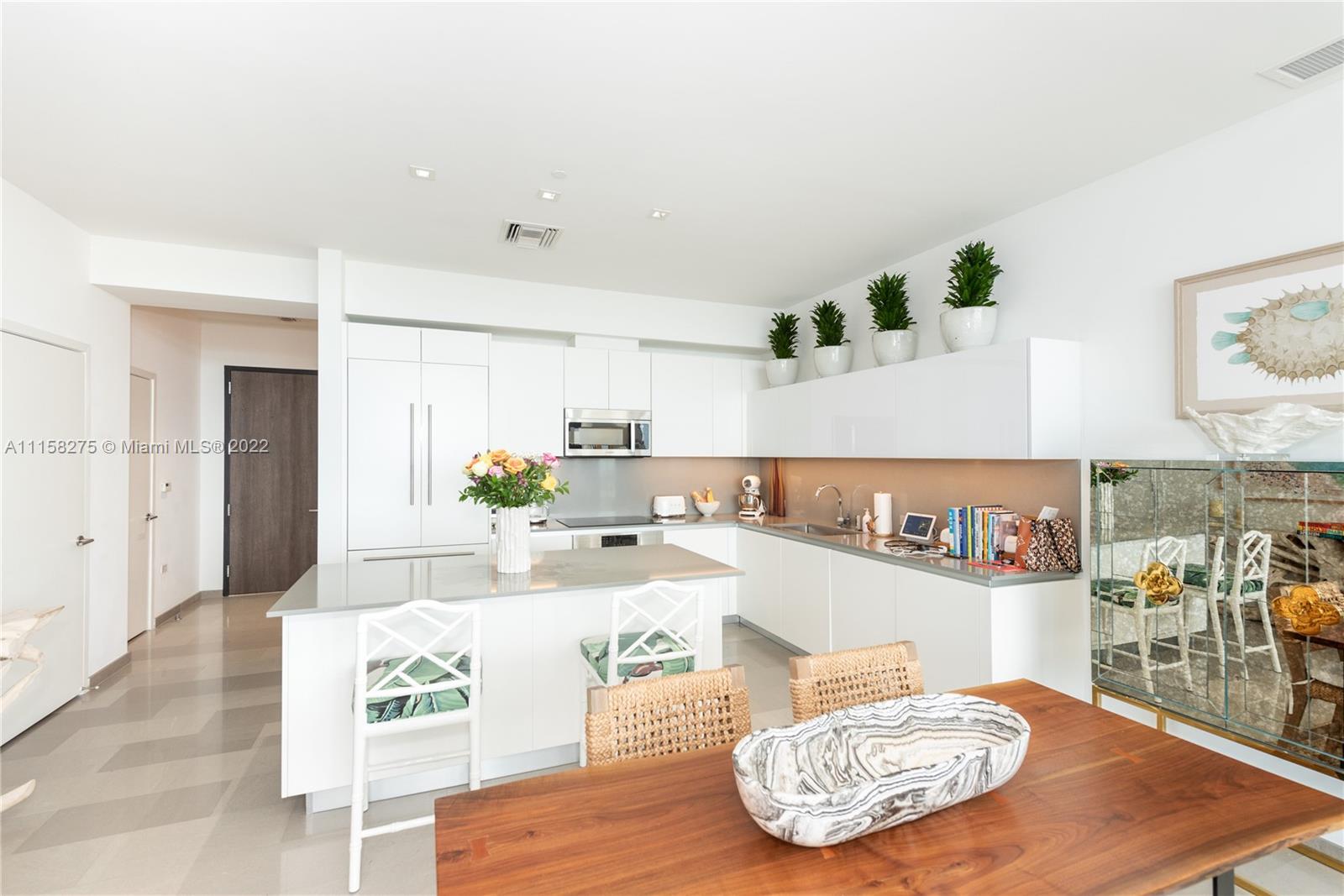 88 Southwest 7th Street, Unit 4110 Miami, FL 33130 - Photo 4 of 33 a kitchen with stainless steel appliances kitchen island granite countertop a table and chairs in it