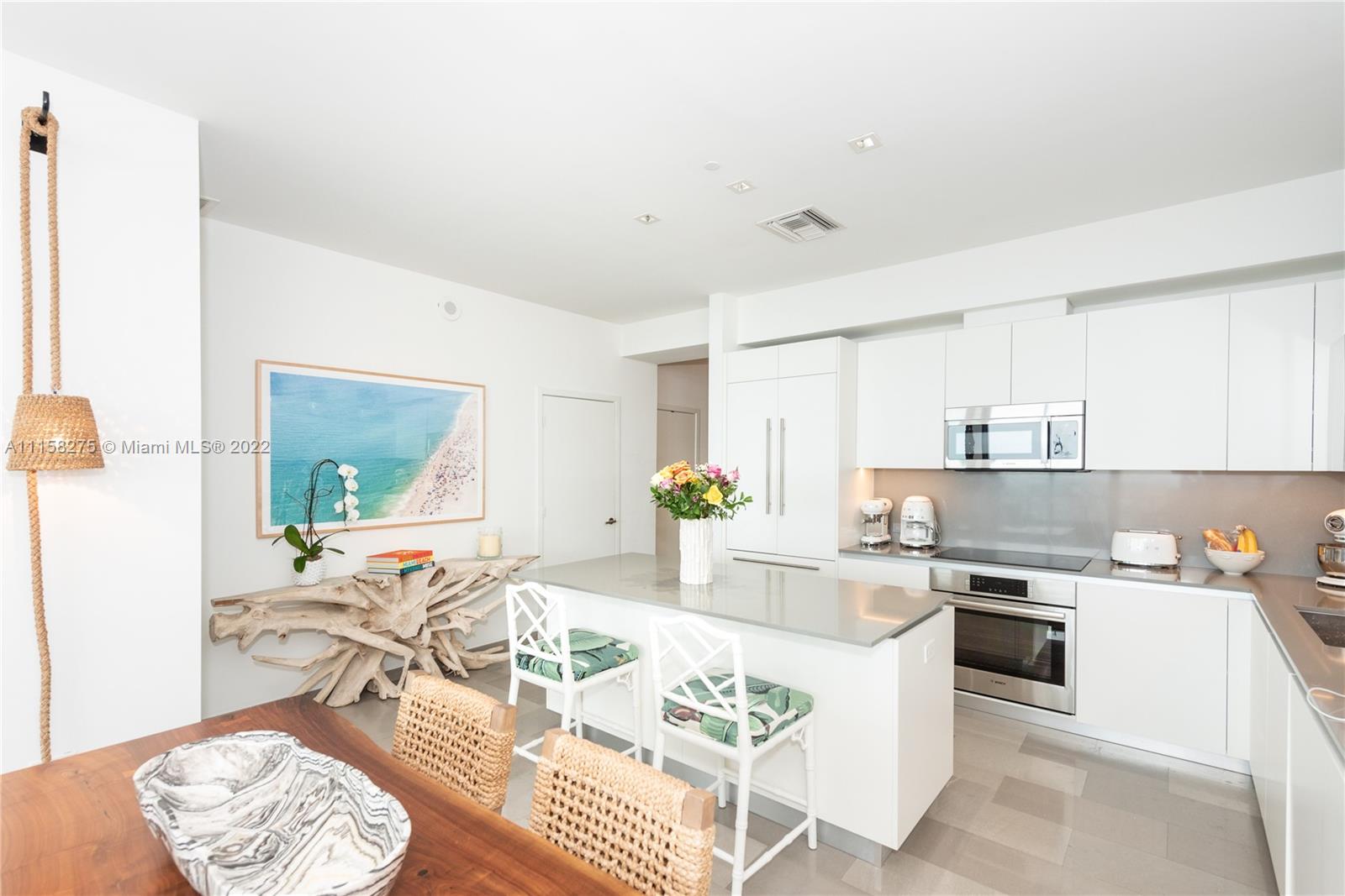 88 Southwest 7th Street, Unit 4110 Miami, FL 33130 - Photo 5 of 33 a kitchen with stainless steel appliances granite countertop a stove a sink dishwasher and white cabinets with wooden floor