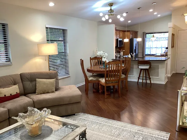 a living room with furniture kitchen and a large window