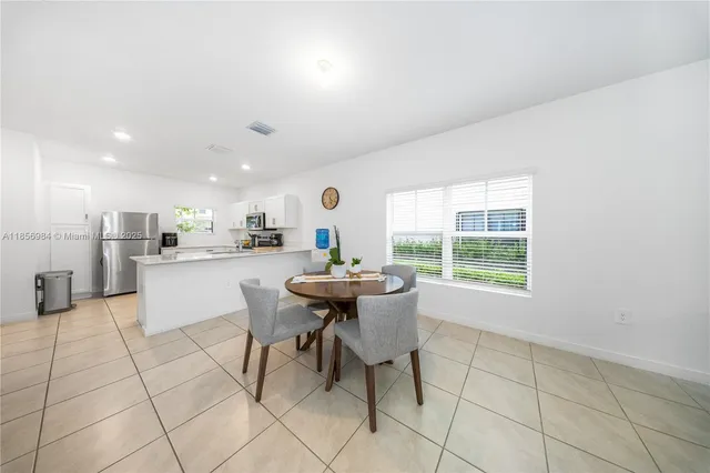 a kitchen with stainless steel appliances kitchen island granite countertop a sink and white cabinets