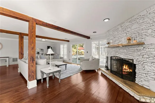 a living room with furniture flat screen tv and a large window