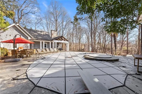 a view of a house with large trees and wooden fence