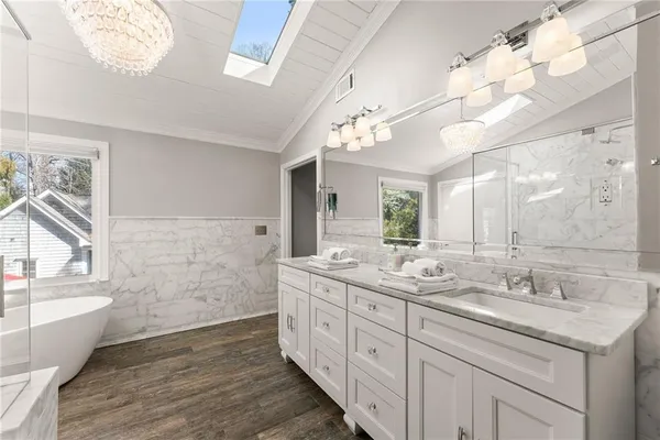 a bathroom with a sink a mirror a toilet and shower