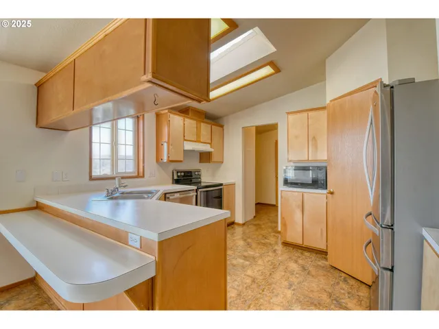 a kitchen with stainless steel appliances granite countertop a sink refrigerator and cabinets