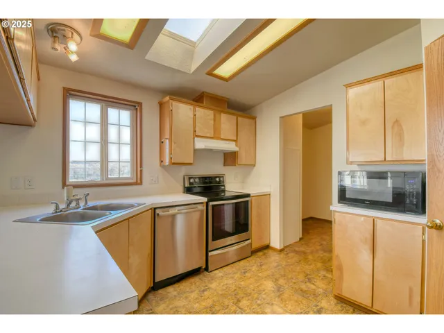 a kitchen with stainless steel appliances granite countertop a sink and a stove
