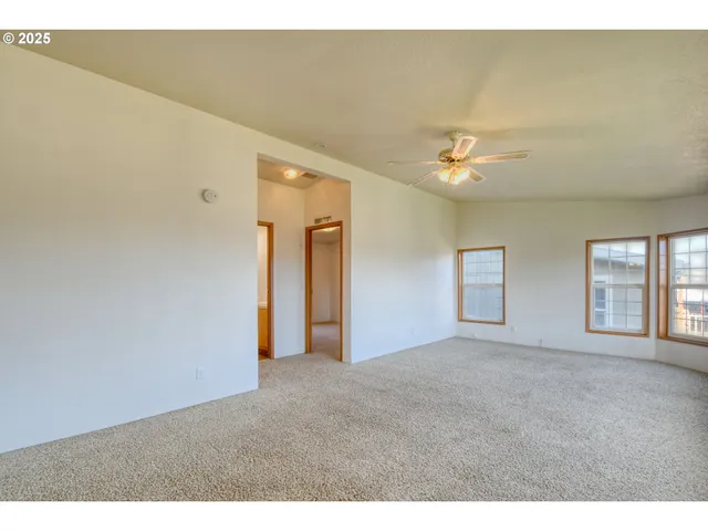 a view of a livingroom with a ceiling fan and window
