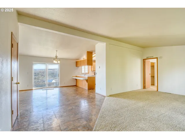 a view of empty room with wooden floor and windows