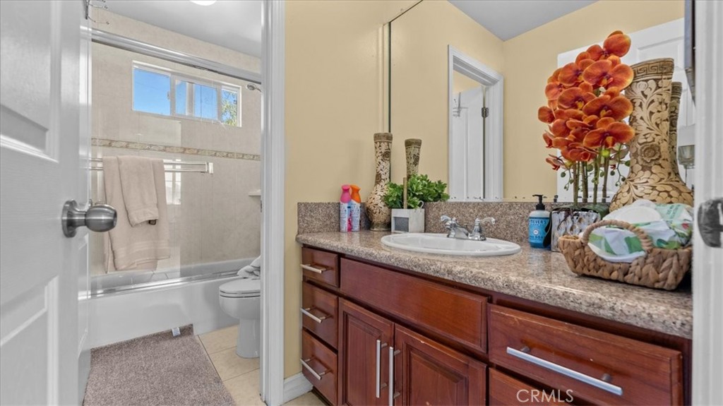 10115 Onyx Way Riverside, CA 92503 - Photo 12 of 18 a bathroom with a granite countertop sink a toilet and a mirror