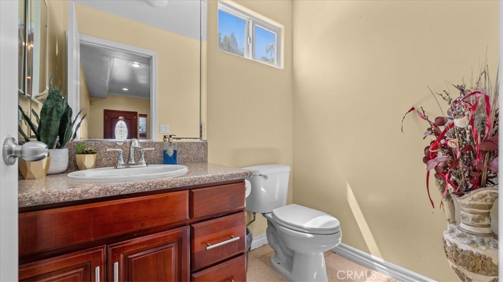 10115 Onyx Way Riverside, CA 92503 - Photo 17 of 18 a bathroom with a granite countertop sink mirror vanity and toilet