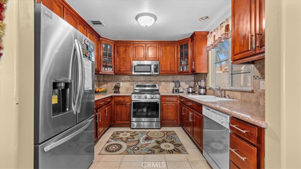 10115 Onyx Way Riverside, CA 92503 - Photo 5 of 18 a kitchen with stainless steel appliances granite countertop a stove a sink and a refrigerator