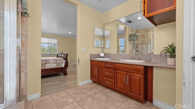 a spacious bathroom with a granite countertop sink and a mirror