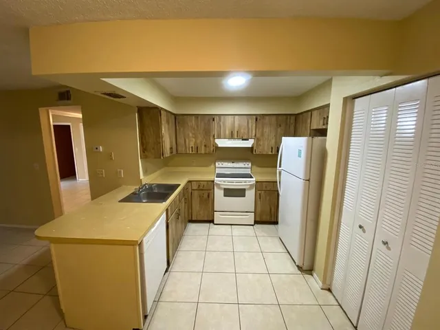 a kitchen with a refrigerator sink and cabinets
