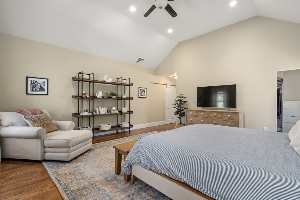 33 Centre Street Dover, MA 02030 - Photo 14 of 32 a spacious bedroom with a bed a couch and a flat screen tv