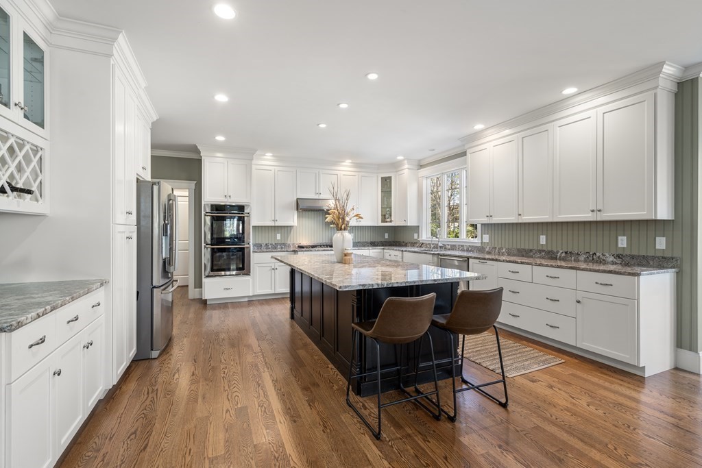 33 Centre Street Dover, MA 02030 - Photo 4 of 32 a kitchen with stainless steel appliances granite countertop a table chairs sink refrigerator and cabinets