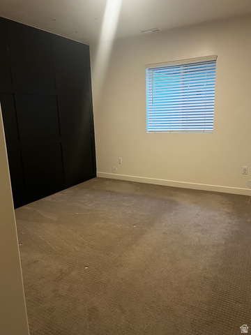 315 South Sherman Street Mapleton, UT 84664 - Photo 16 of 30 Room featuring a black accent wall with panel detailing, light-toned wall paint, a window with horizontal blinds, and carpeted flooring