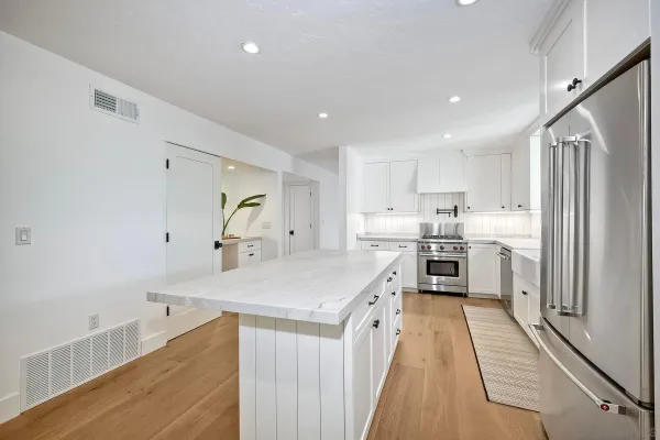 a kitchen that has a lot of cabinets and wooden floor
