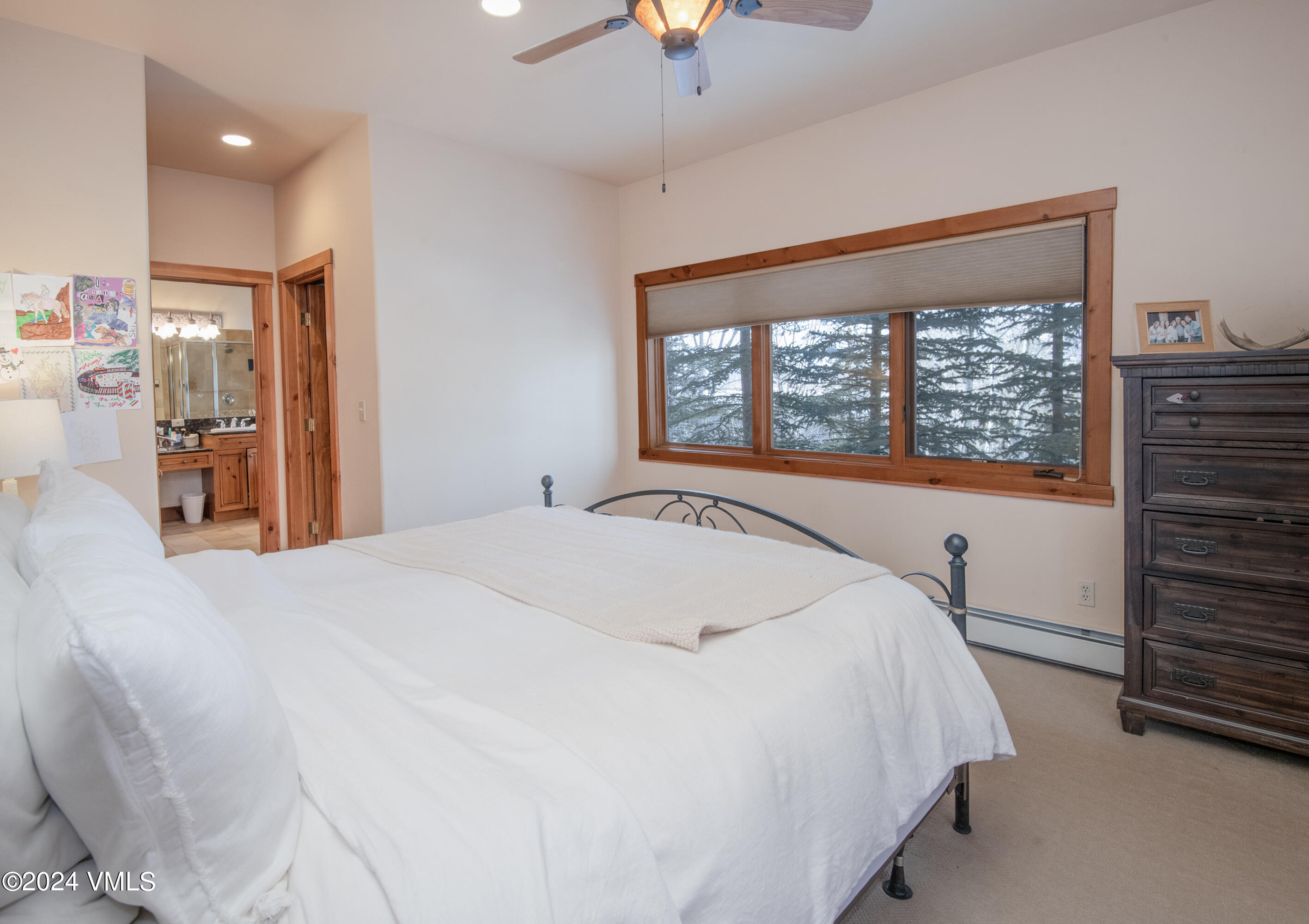 111 Knudson Ranch Road Edwards, CO 81632 - Photo 16 of 31 a spacious bedroom with a large bed and a chandelier