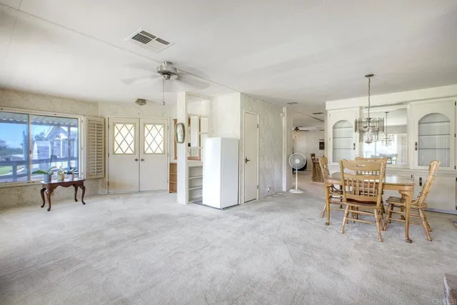a view of a livingroom with furniture and chandelier fan