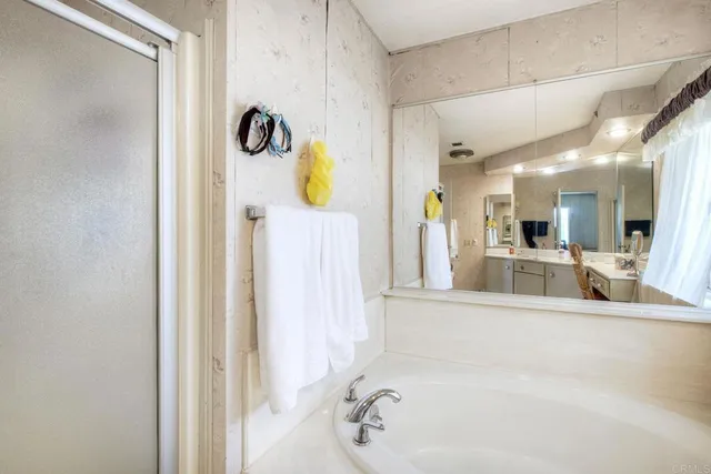 a bathroom with a tub sink and mirror