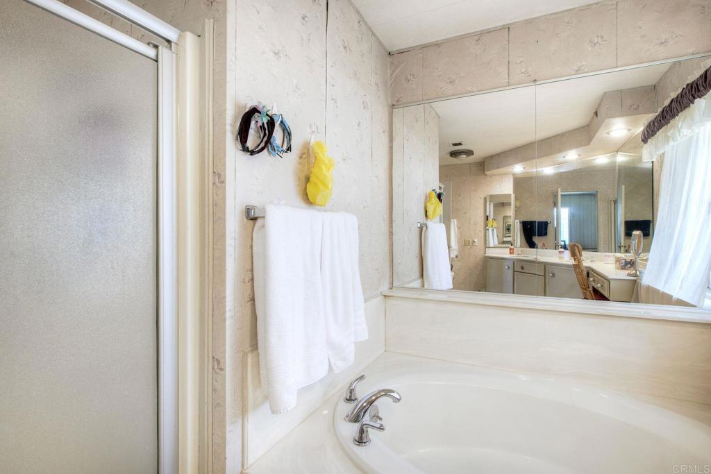 18218 Paradise Mountain Road, Unit 115 Valley Center, CA 92082 - Photo 18 of 27 a bathroom with a tub sink and mirror