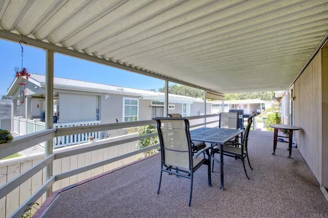 a view of a patio with table and chairs and wooden floor