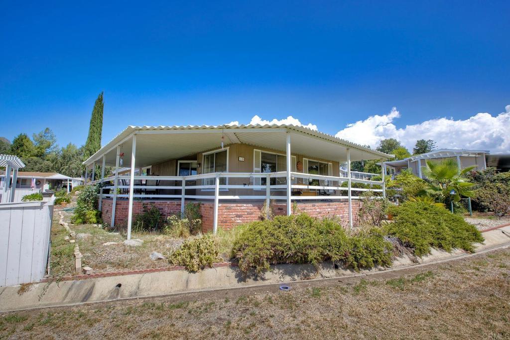 18218 Paradise Mountain Road, Unit 115 Valley Center, CA 92082 - Photo 26 of 27 a front view of a house with a garden