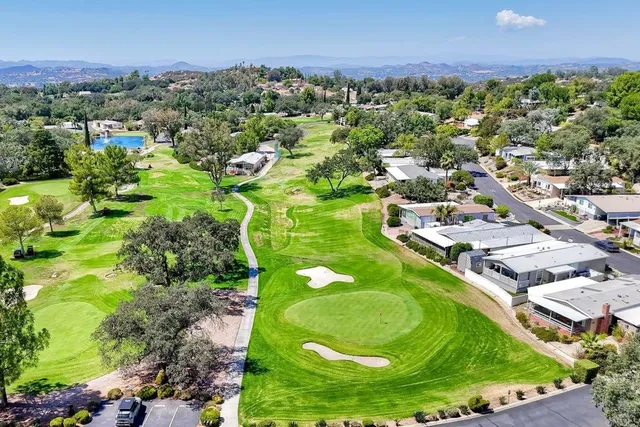 an aerial view of residential houses with outdoor space and trees