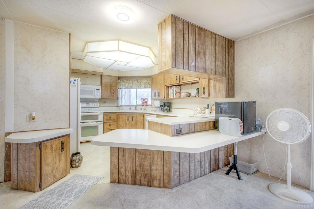 18218 Paradise Mountain Road, Unit 115 Valley Center, CA 92082 - Photo 7 of 27 a kitchen with a cabinets and window