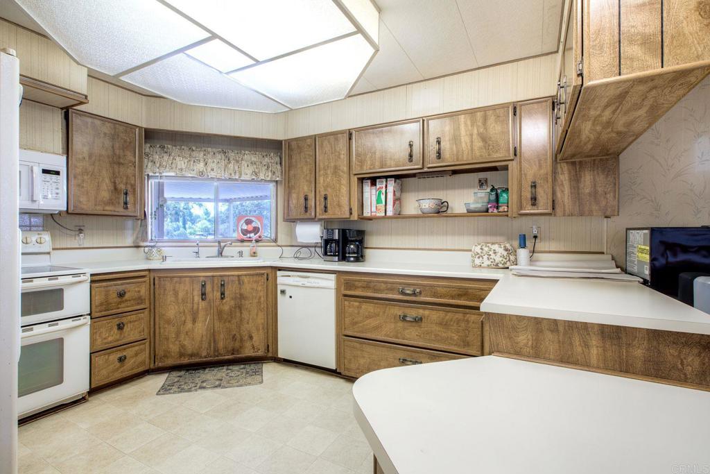 18218 Paradise Mountain Road, Unit 115 Valley Center, CA 92082 - Photo 8 of 27 a kitchen with a sink cabinets and window