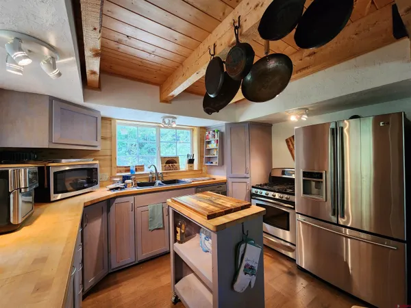 a kitchen with stainless steel appliances granite countertop a sink a stove and a refrigerator