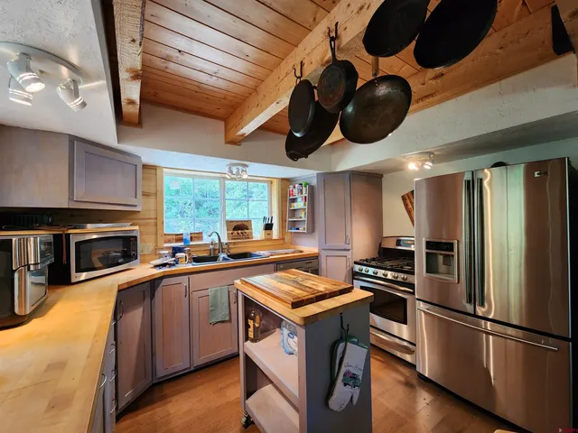 a kitchen with stainless steel appliances granite countertop a sink a stove and a refrigerator