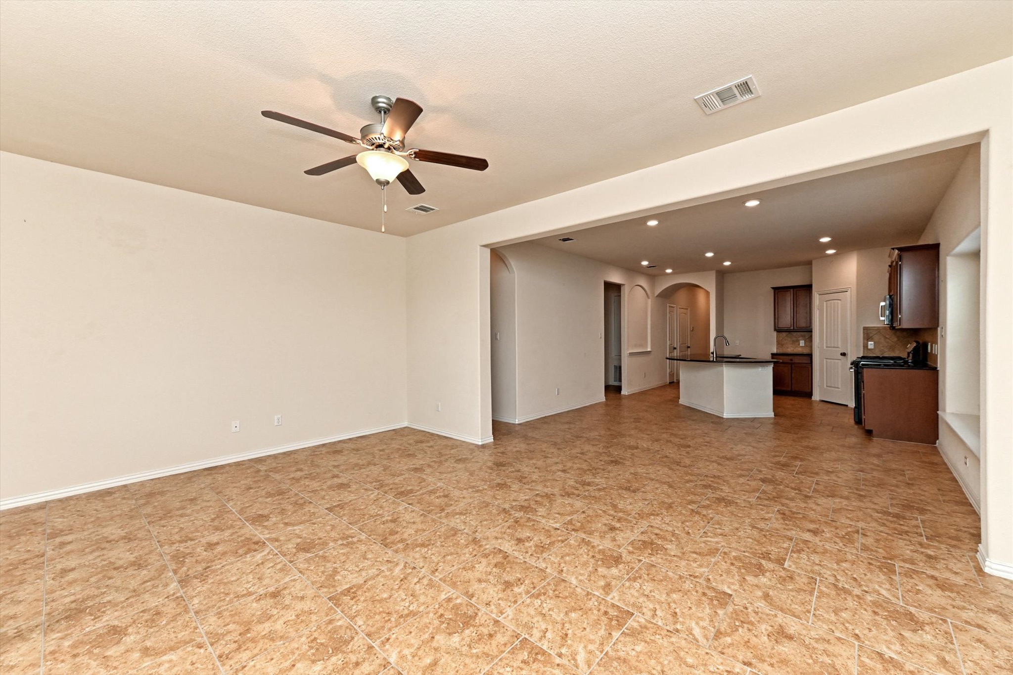265 Shale Circle Buda, TX 78610 - Photo 12 of 29 Unfurnished living room featuring arched walkways, a ceiling fan, and recessed lighting