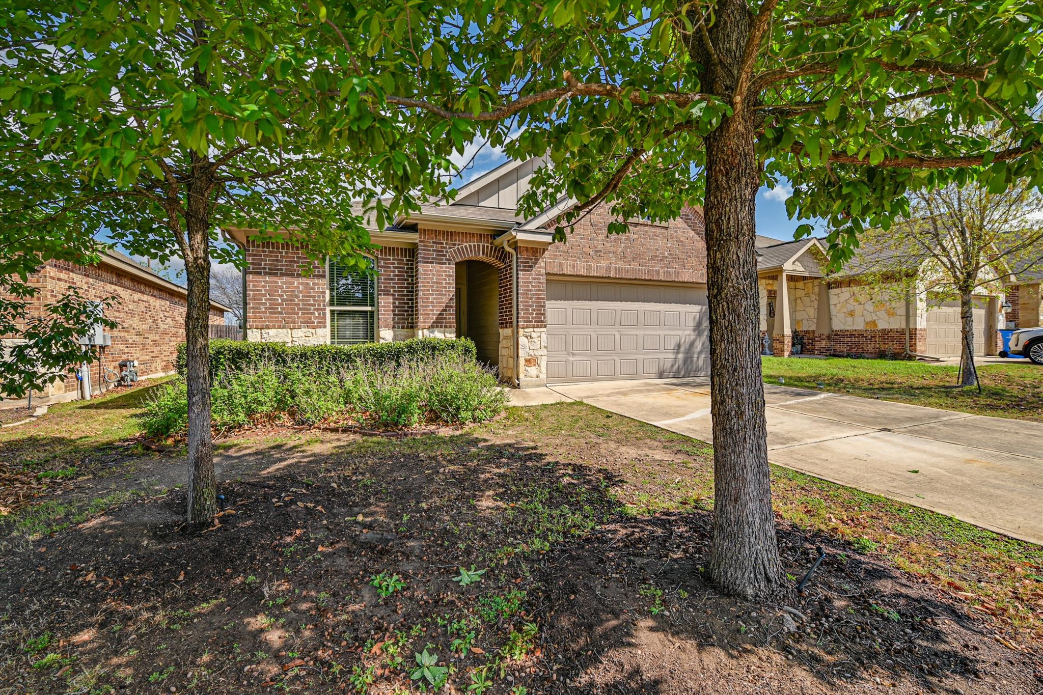 265 Shale Circle Buda, TX 78610 - Photo 2 of 29 View of front of home featuring concrete driveway, brick siding, and an attached garage