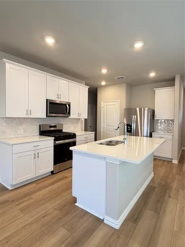 a large kitchen with stainless steel appliances granite countertop a large counter top and a stove top oven