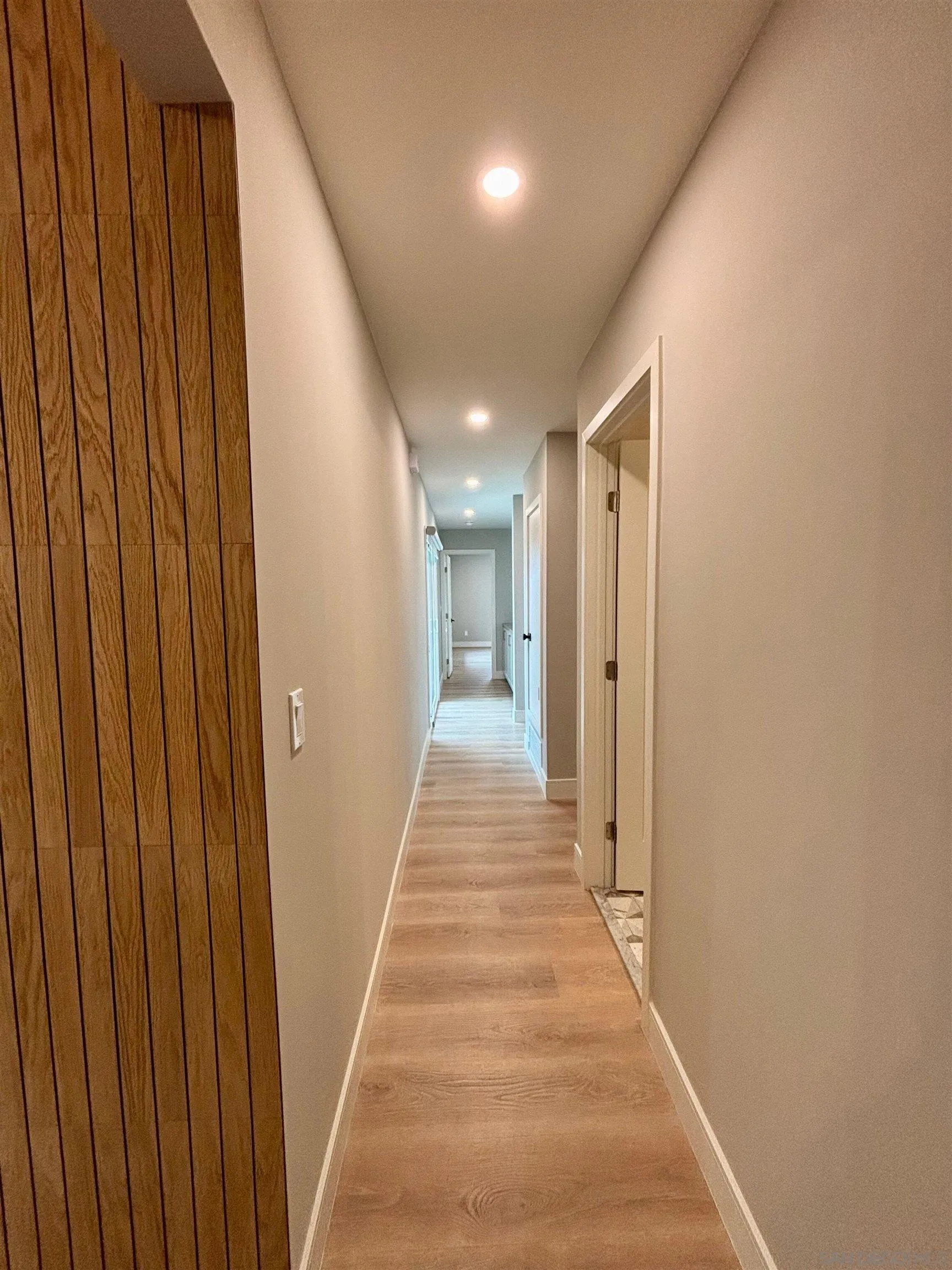 4856 Pacifica Drive San Diego, CA 92109 - Photo 13 of 32 a view of a hallway with wooden floor and staircase