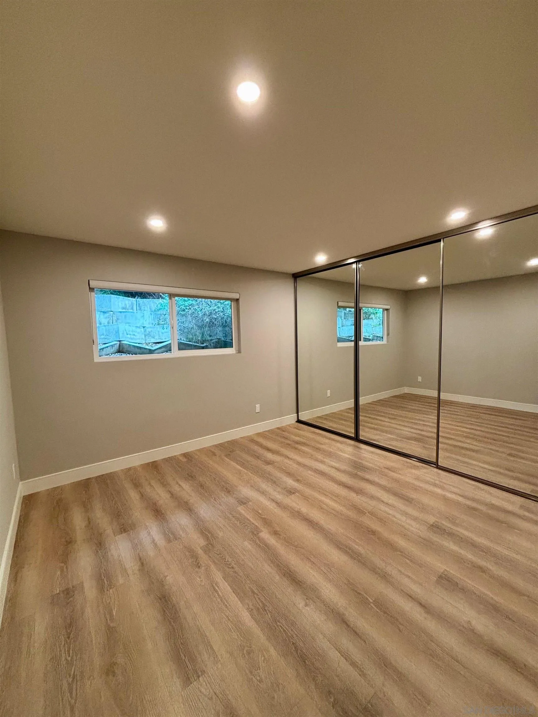 4856 Pacifica Drive San Diego, CA 92109 - Photo 15 of 32 a view of an empty room with window and wooden floor