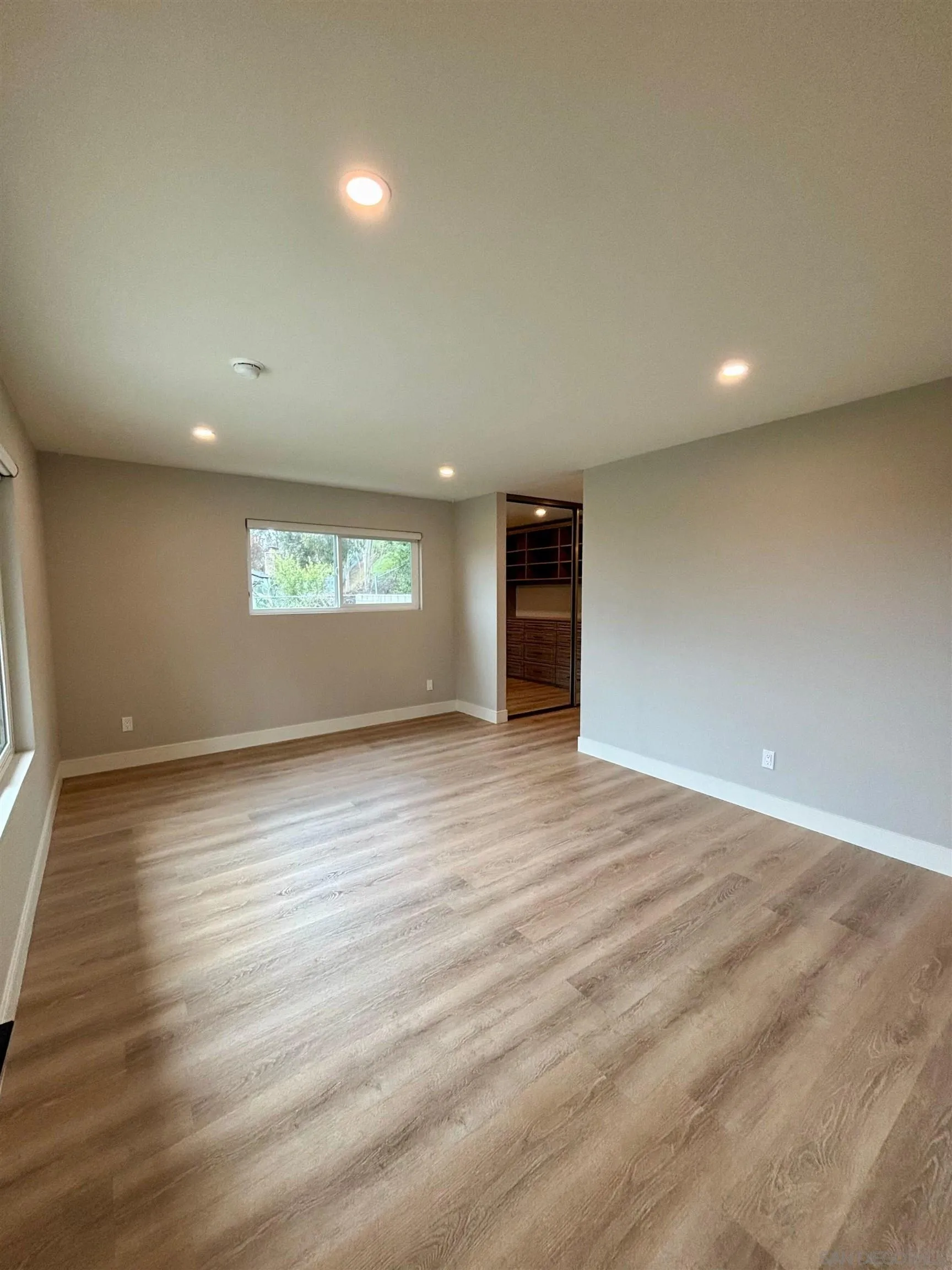 4856 Pacifica Drive San Diego, CA 92109 - Photo 20 of 32 an empty room with wooden floor and windows