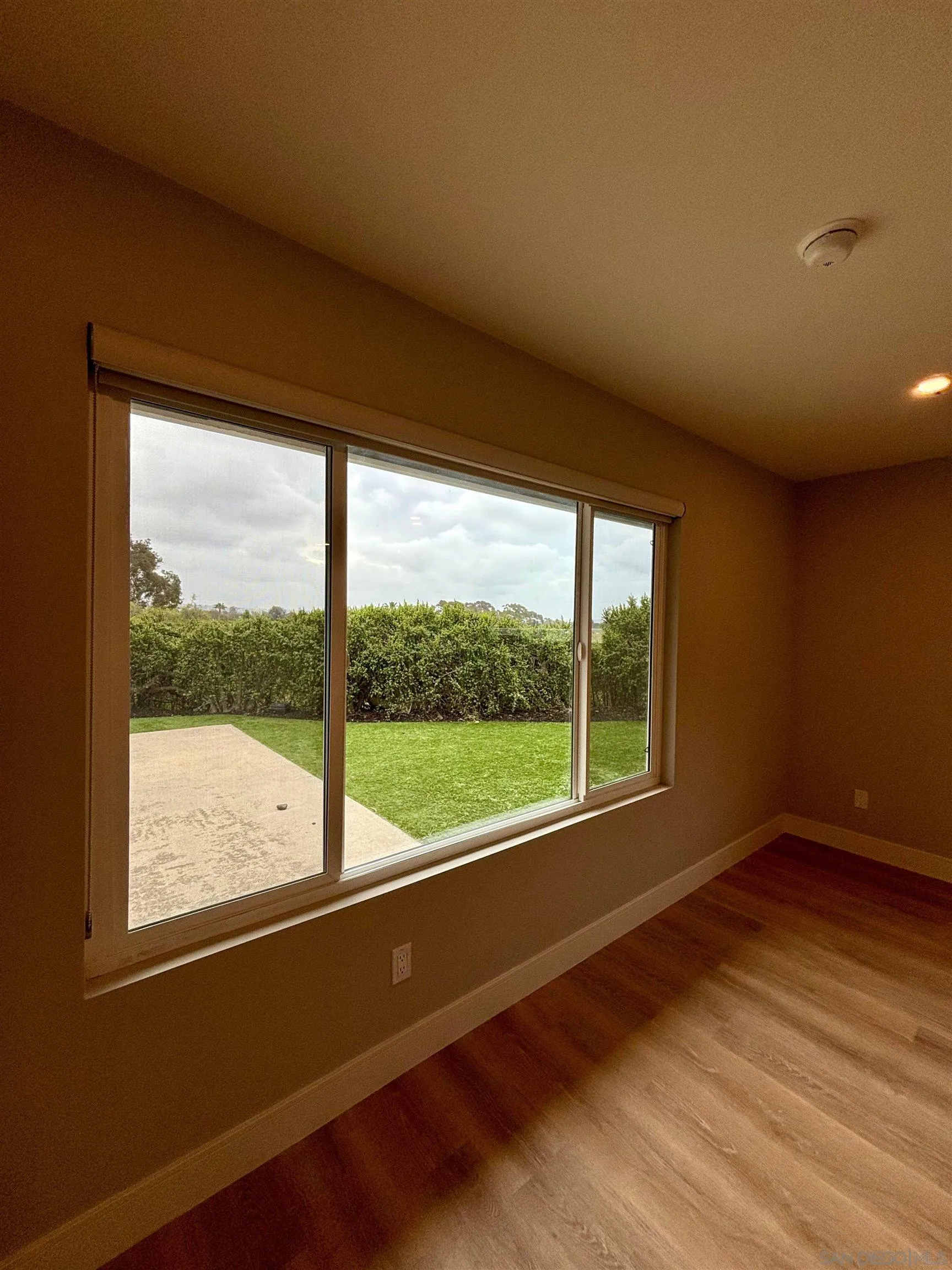 4856 Pacifica Drive San Diego, CA 92109 - Photo 21 of 32 a view of an empty room with wooden floor and a window