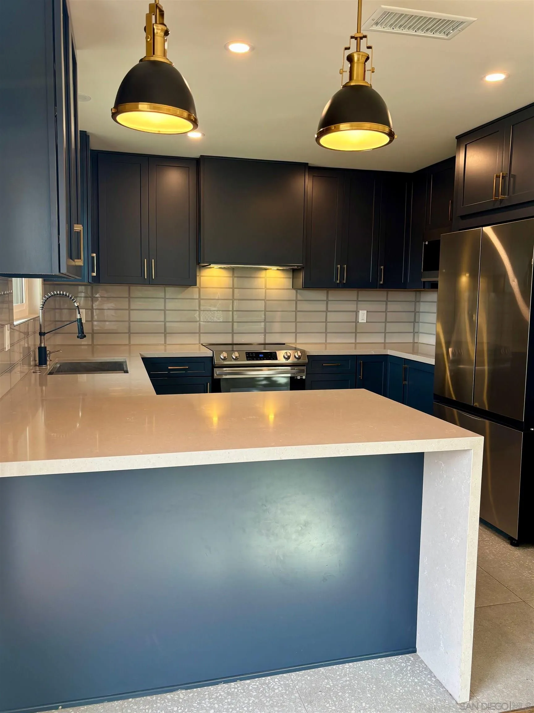 4856 Pacifica Drive San Diego, CA 92109 - Photo 5 of 32 a kitchen with stainless steel appliances a sink a stove and a wooden cabinets
