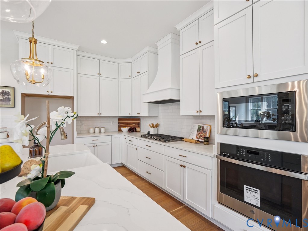 1530 Smokey Rdg Road Maidens, VA 23102 - Photo 8 of 42 a kitchen with granite countertop a stove a sink dishwasher and white cabinets with wooden floor
